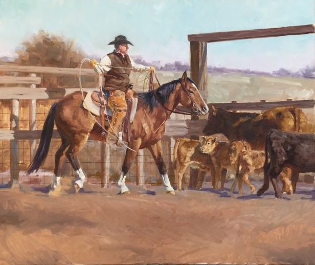 Mounted cowboy working cattle in a ranch corral while holding a looped rope