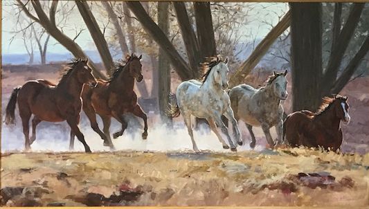 Five horses running through sunlit trees with dust rising around them