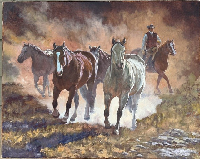 Band of horses moving through dust with a mounted cowboy following behind