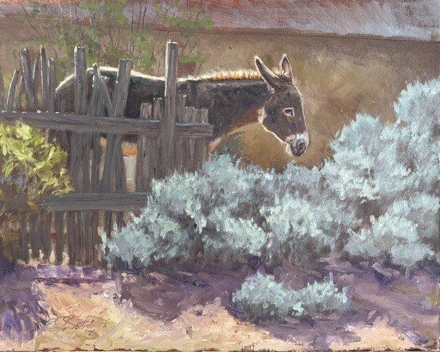 Donkey looking over silvery sagebrush beside a rustic wooden corral in Killing Time